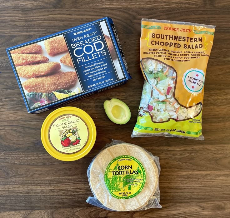 some food is laying out on a wooden table next to it's packaging and chips