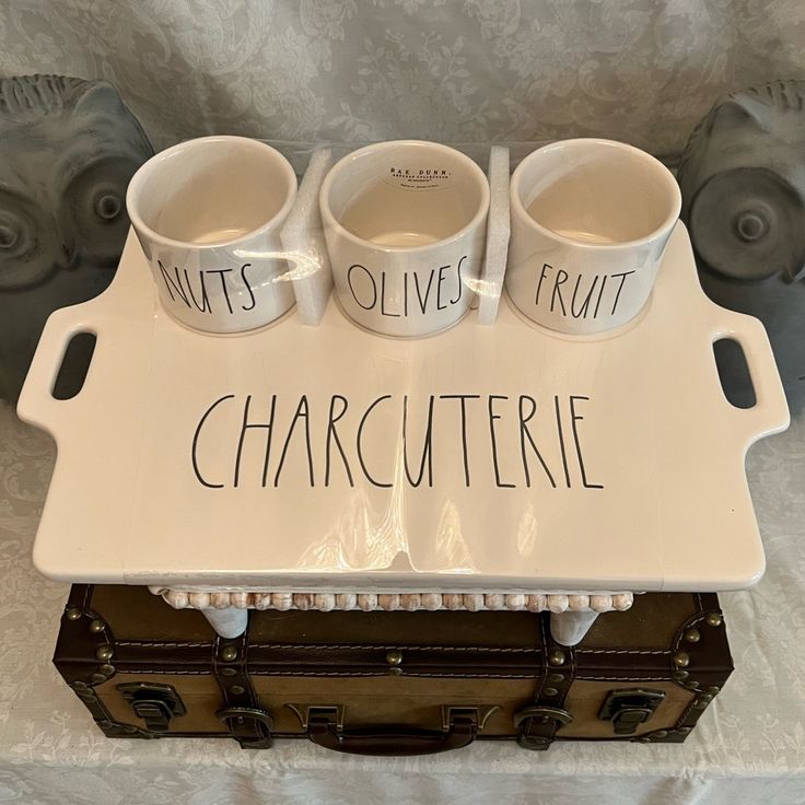 three coffee mugs sitting on top of a tray with words written on the cups