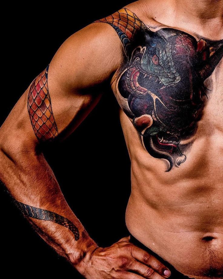 a man with a dragon tattoo on his chest and arm is posing for the camera