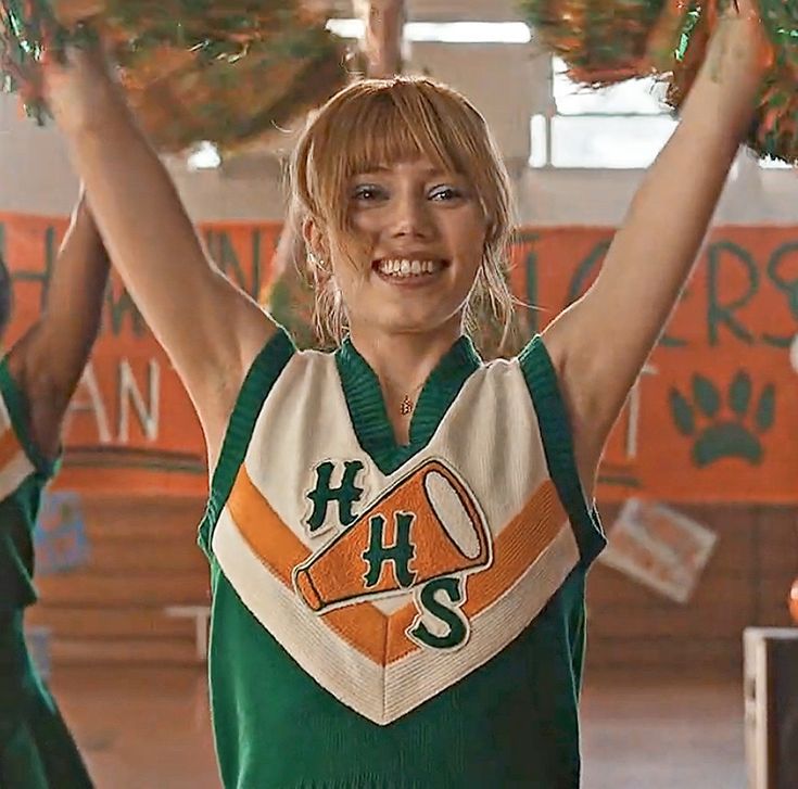 the cheerleaders are holding their pom poms in one hand and smiling at the camera