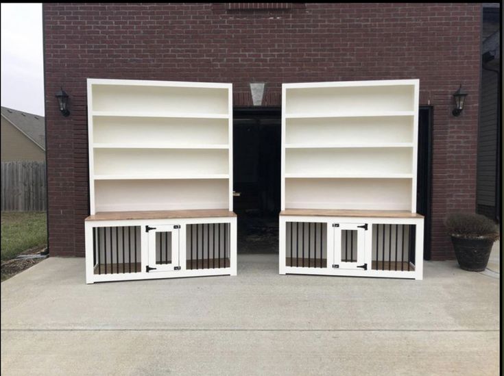 two white bookcases with doors open on concrete