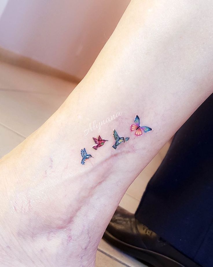 a woman's foot with three butterflies on it