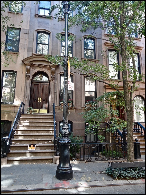 an apartment building with stairs leading up to the front door and steps down to the street