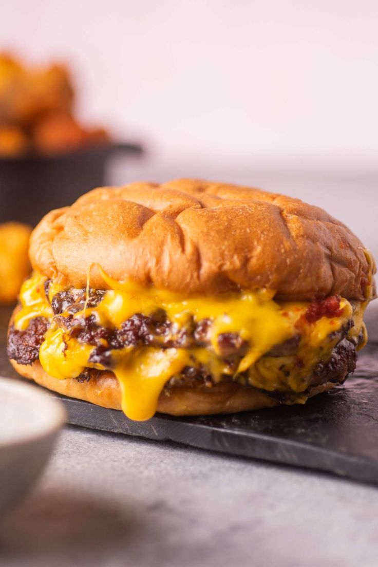 a cheeseburger sitting on top of a cutting board