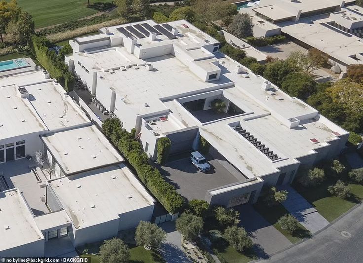 an aerial view of a large white house with lots of windows on the top floor