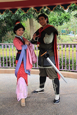 a man and woman dressed up in traditional chinese costumes posing for a photo under an awning