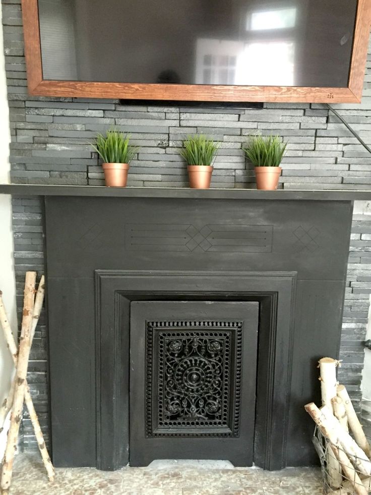 a fireplace with potted plants on the mantle