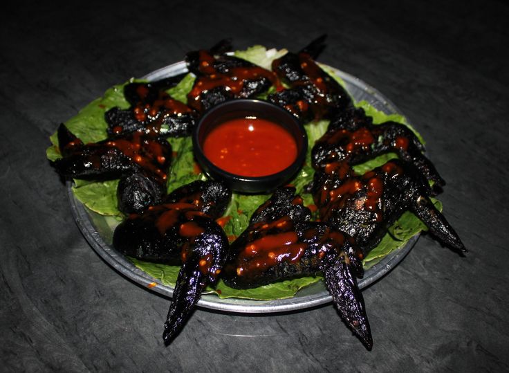 a white plate topped with lots of food on top of a wooden table next to a red sauce