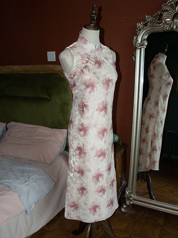 Embrace timeless elegance with this sleeveless dress, meticulously crafted to revive the vintage charm of traditional Chinese fashion. The soft pink fabric is adorned with intricate red spider lily prints, symbolizing beauty and renewal. The dress features a classic mandarin collar and side slits, offering both comfort and a flattering silhouette. Perfect for special occasions or adding a touch of sophistication to your everyday wardrobe, this vintage-inspired piece is a must-have for any fashio Sleeveless Spring Wedding Cheongsam, Spring Wedding Sleeveless Cheongsam, Red Sleeveless Fitted Cheongsam, Red Fitted Sleeveless Cheongsam, Elegant Sleeveless Red Cheongsam, Elegant Red Sleeveless Cheongsam, Elegant Pink Sleeveless Dress With Floral Print, Elegant Pink Floral Print Sleeveless Dress, Fitted Sleeveless Summer Cheongsam