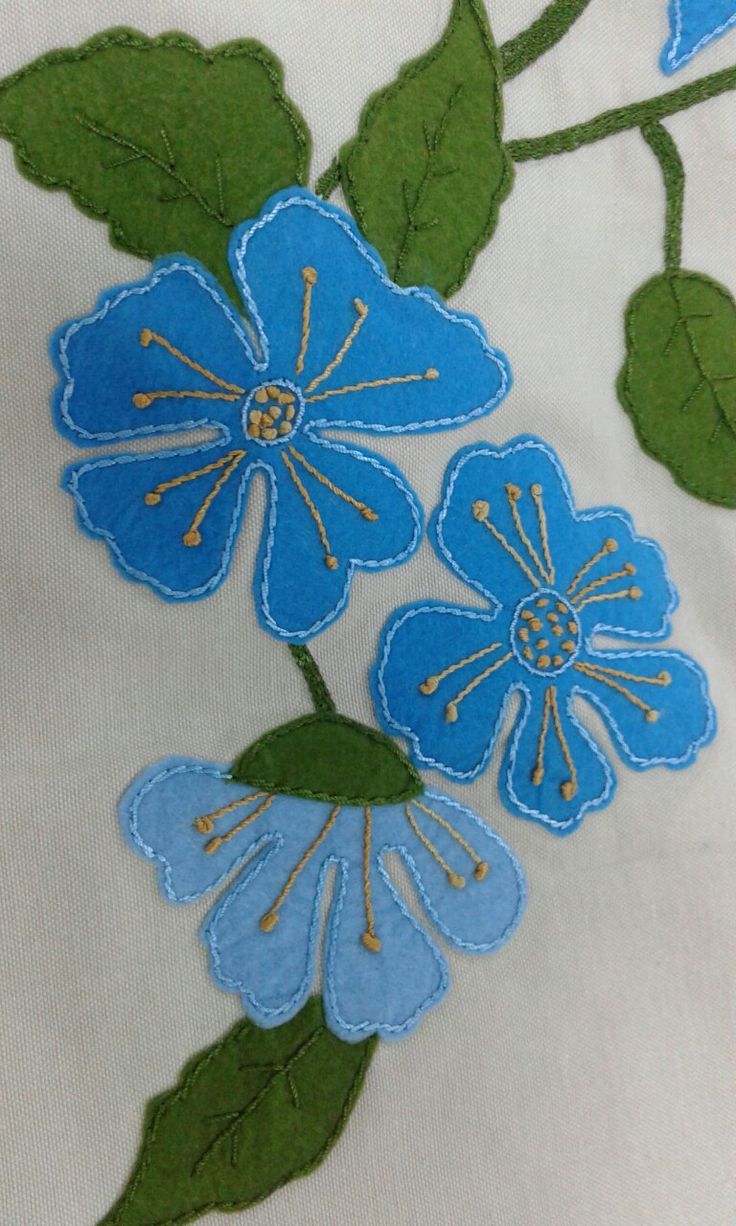 blue flowers on white fabric with green leaves