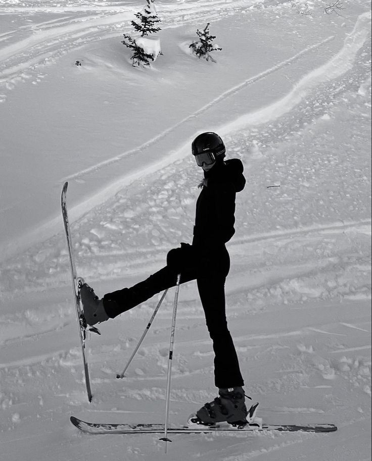 a person riding skis on top of a snow covered slope