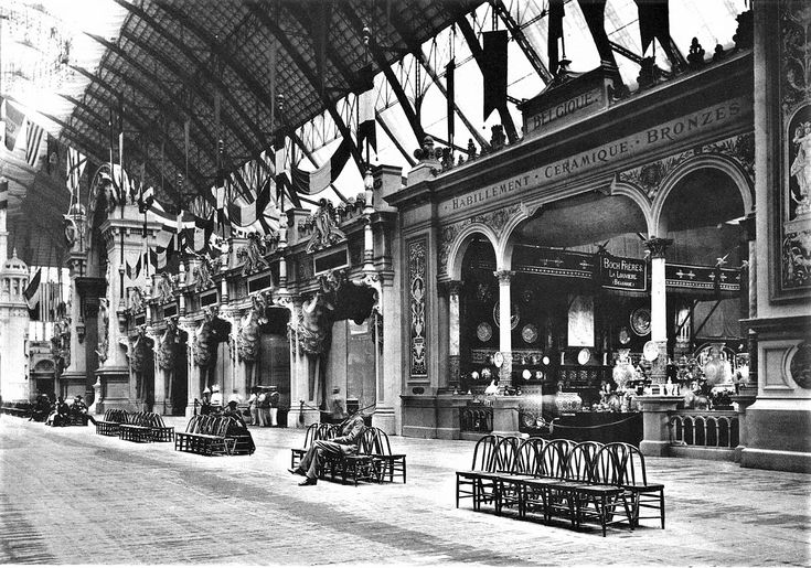 an old black and white photo of the inside of a train station with people sitting on benches