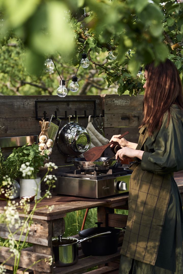 a woman cooking food on an outdoor grill