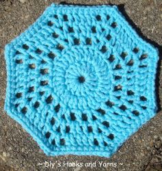 a blue crocheted doily sitting on the ground