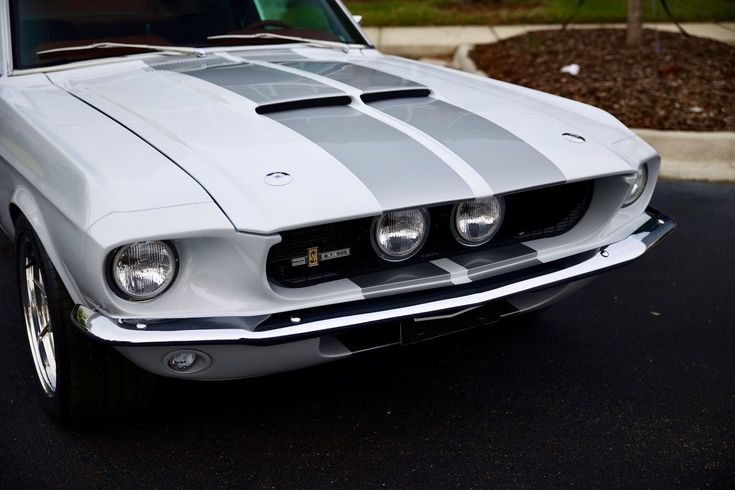 the front end of a white and gray mustang with stripes on it's hood