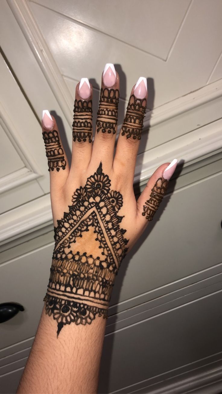 a woman's hand with henna tattoos on it