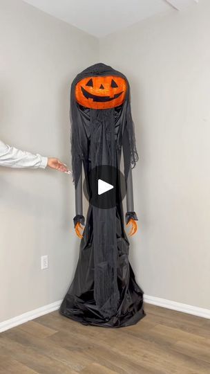 two people standing next to each other in front of a halloween decoration