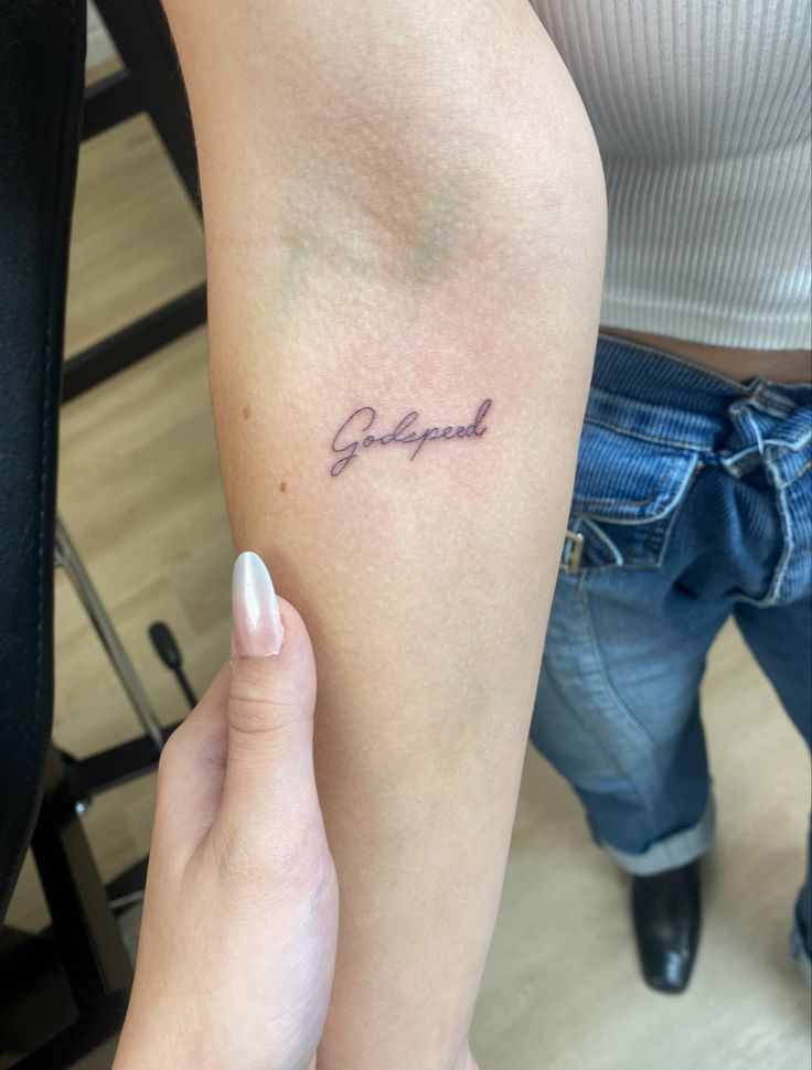 a woman with a tattoo on her arm that reads,'grateful'in cursive writing