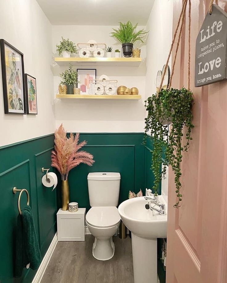 a white toilet sitting in a bathroom next to a sink and green painted wall behind it