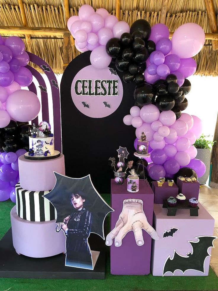 a table topped with lots of purple and black balloons on top of boxes filled with items