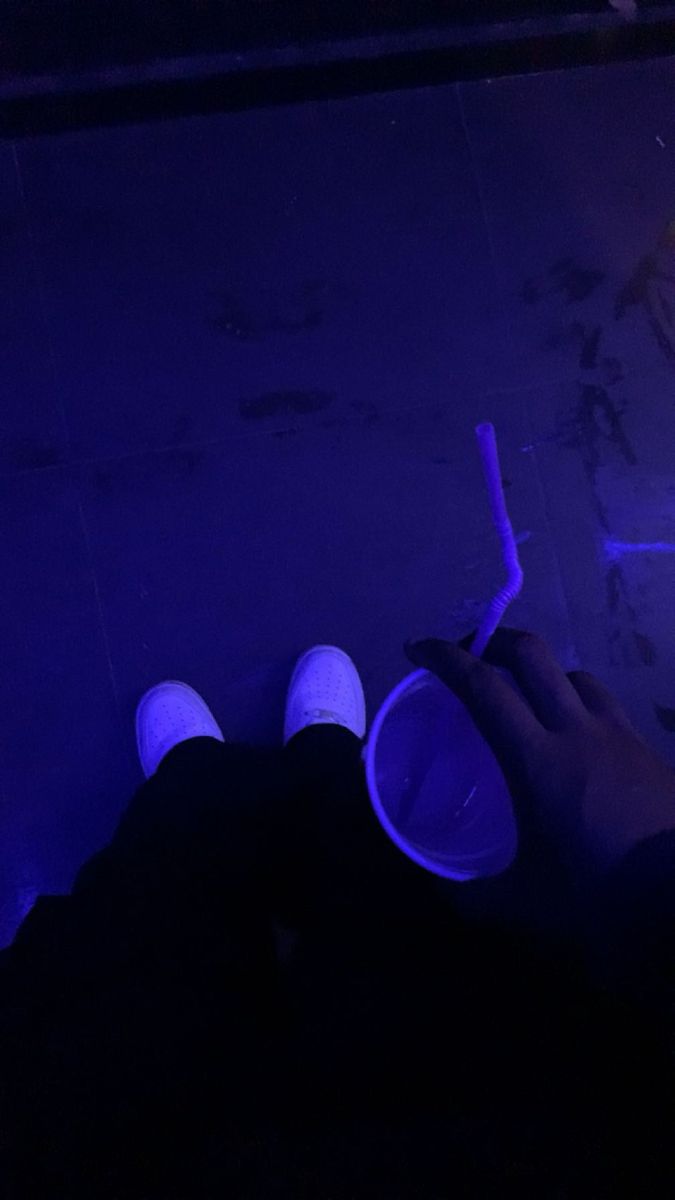 a person holding a toothbrush in their left hand while sitting on the floor at night