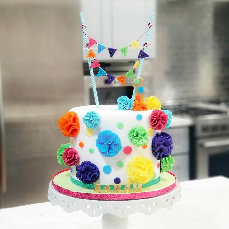 a multi - colored cake on a white table in a kitchen