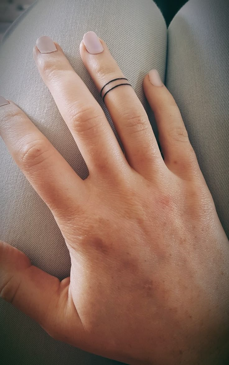 a woman's hand with two rings on it