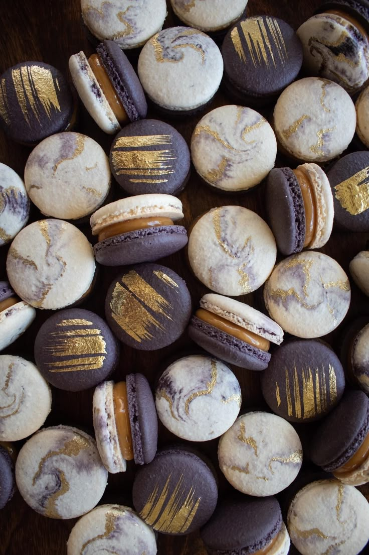 chocolate macaroons with gold leaf designs on them