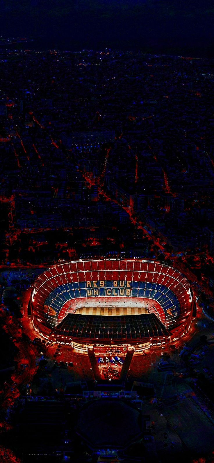 an aerial view of a stadium lit up in red, white and blue at night