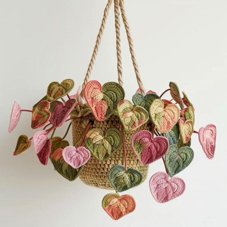 a hanging basket filled with crocheted heart shaped leaves and hearts attached to strings