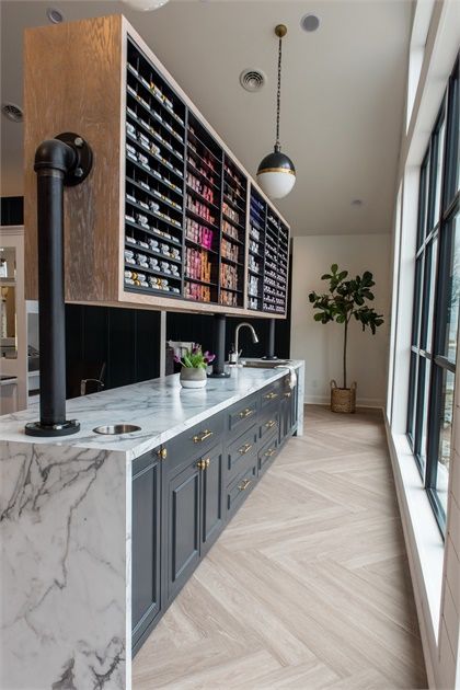 a kitchen with marble counter tops and gray cabinets, along with large windows that look out onto the outdoors