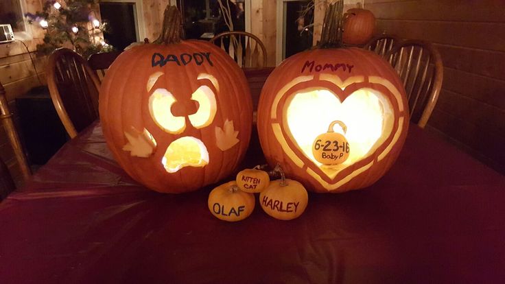 two carved pumpkins sitting on top of a table