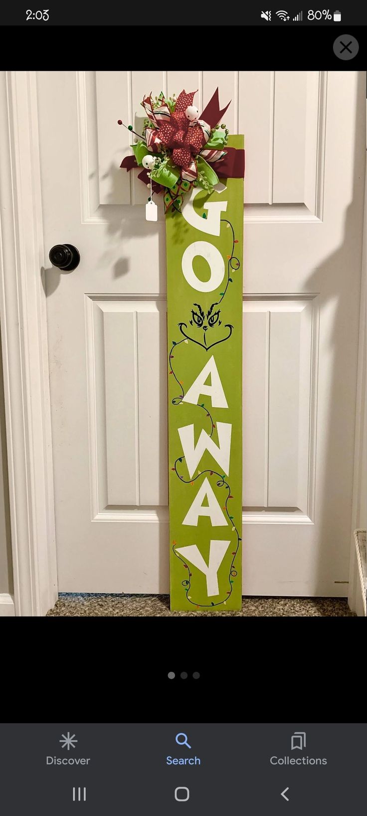 a green sign with the word holiday hanging on it's side in front of a door