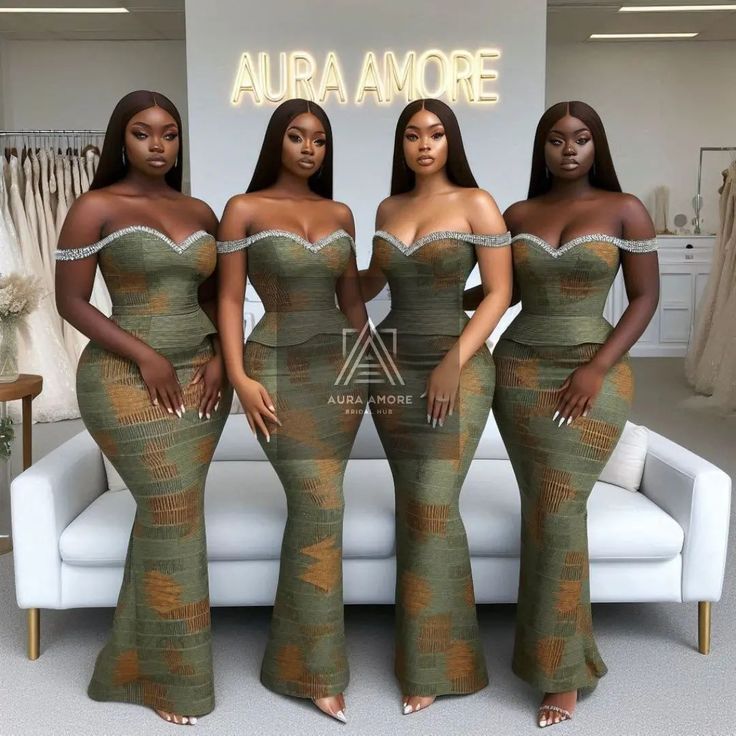 three women in green dresses standing next to each other on a white couch and posing for the camera