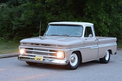 an old pickup truck parked in a parking lot