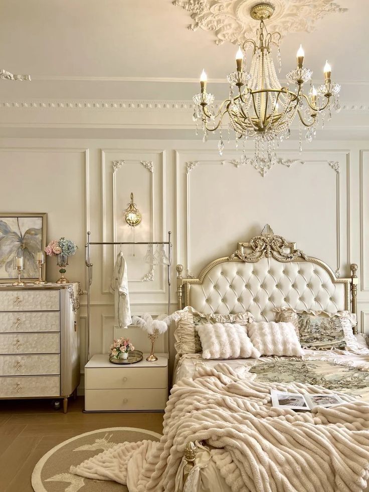 a bedroom with a chandelier, bed and dresser in the middle of it