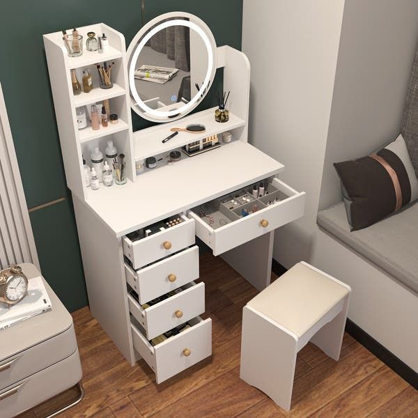 a white dressing table with drawers, mirror and stools next to a couch in a room