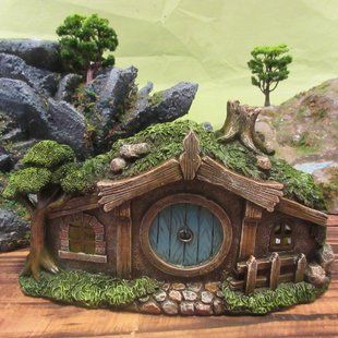 a small house with moss growing on it's roof and trees in the background