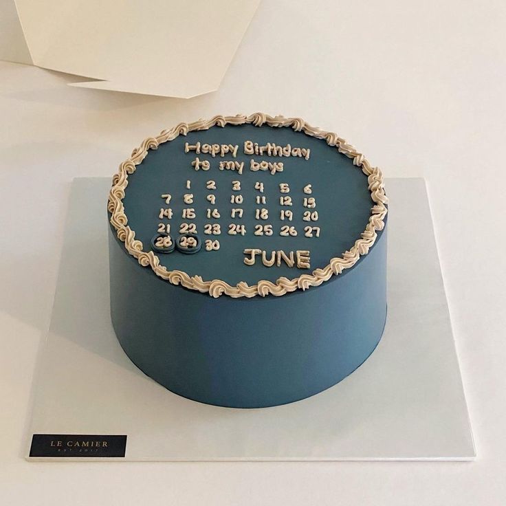 a blue birthday cake sitting on top of a white table next to a sign that says june