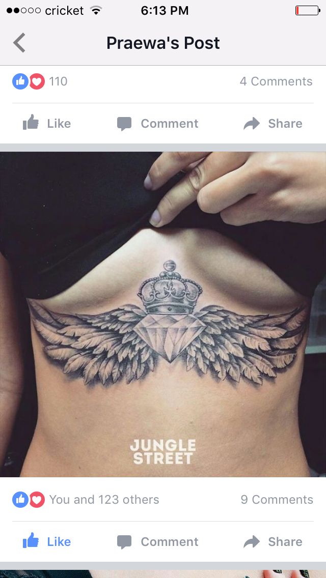 the back of a woman's stomach with angel wings and crown tattoo on it