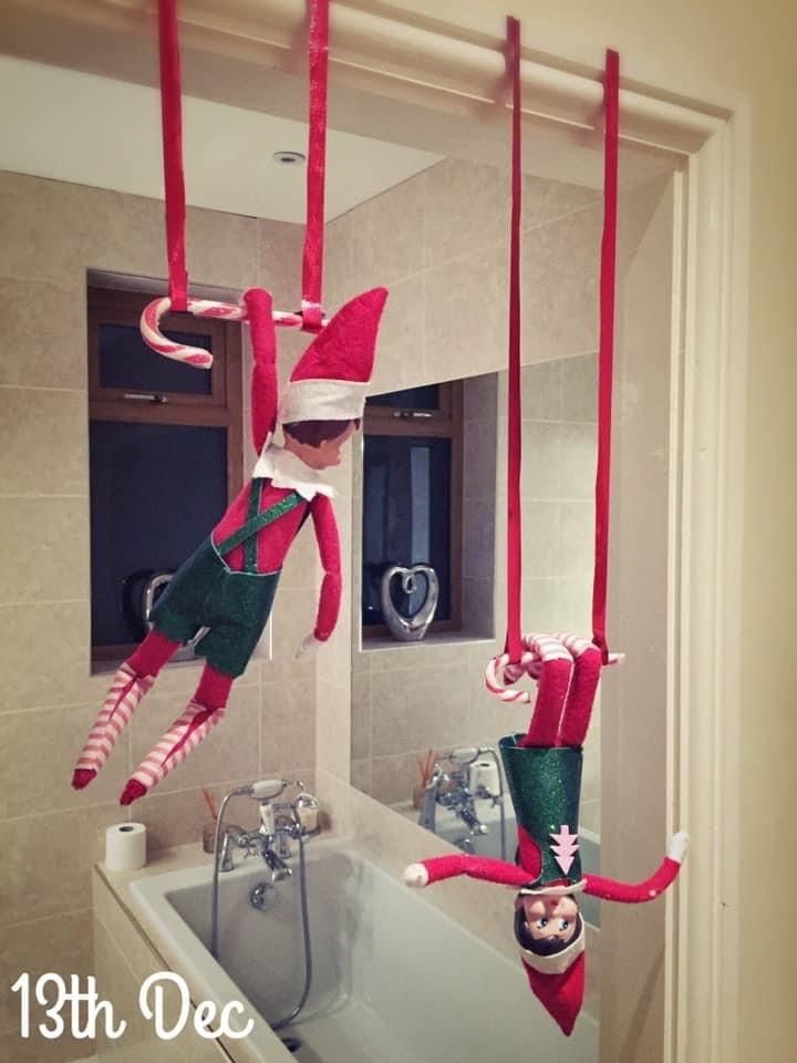 two elfs hanging from the ceiling in a bathroom