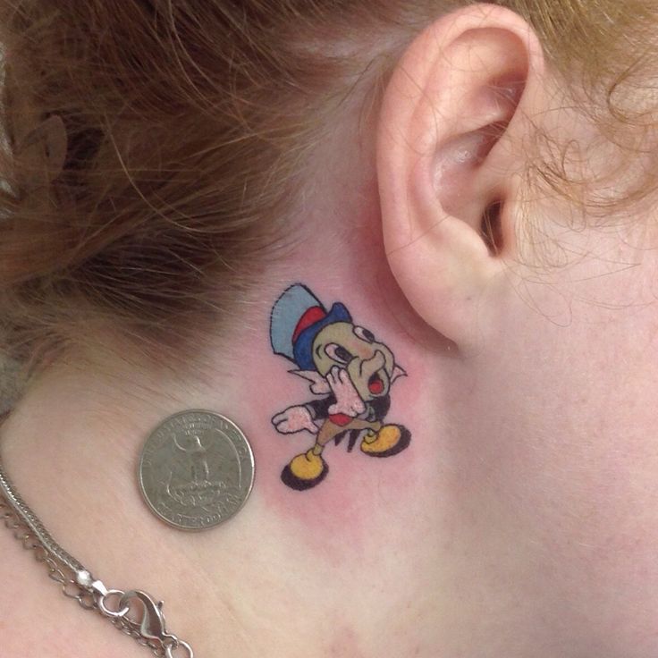 a woman with a small tattoo on her neck and behind the ear is a coin