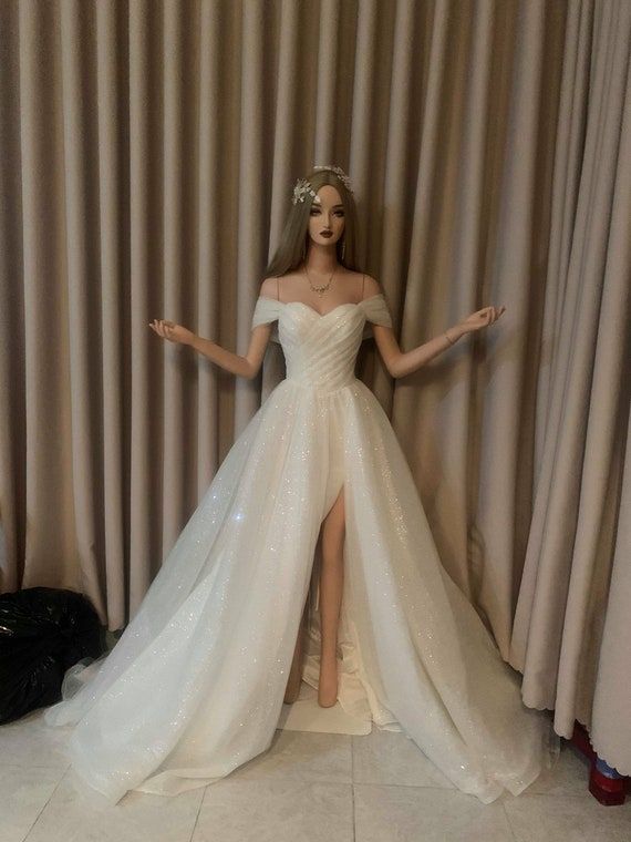 a mannequin dressed in a wedding dress with a slit through the skirt and high heels