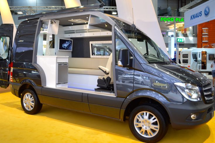 a silver van is on display in a showroom with yellow carpet and white walls