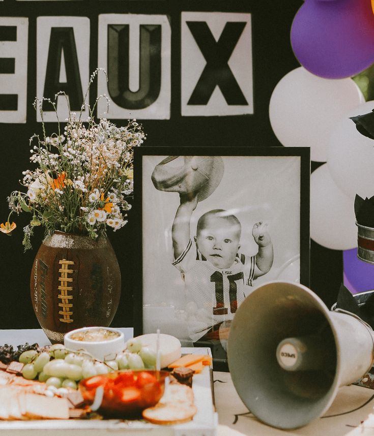 a football themed birthday party with balloons, flowers and pictures on the wall behind it