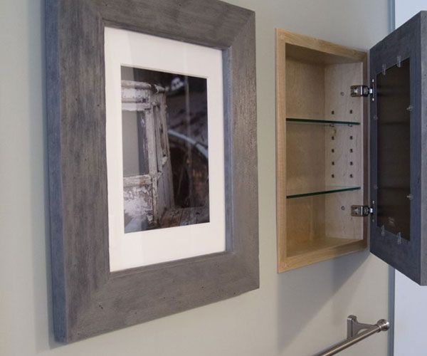 a bathroom with a sink, toilet paper dispenser and pictures on the wall