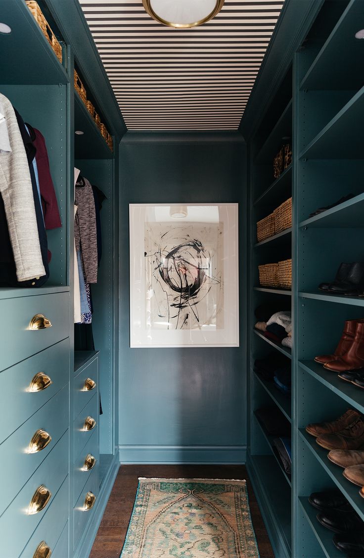 a walk - in closet with blue walls and wooden flooring, built into the ceiling