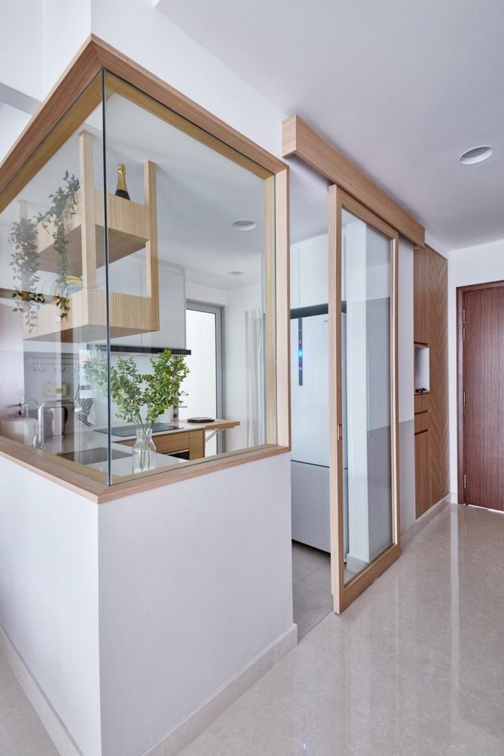 an empty kitchen and living room are seen through the glass walls in this modern home