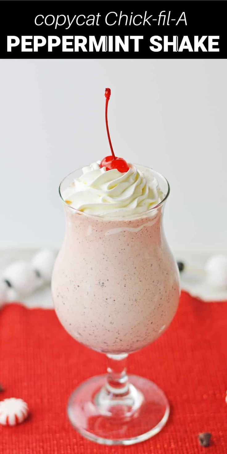 a drink in a glass with whipped cream and a cherry garnish on top