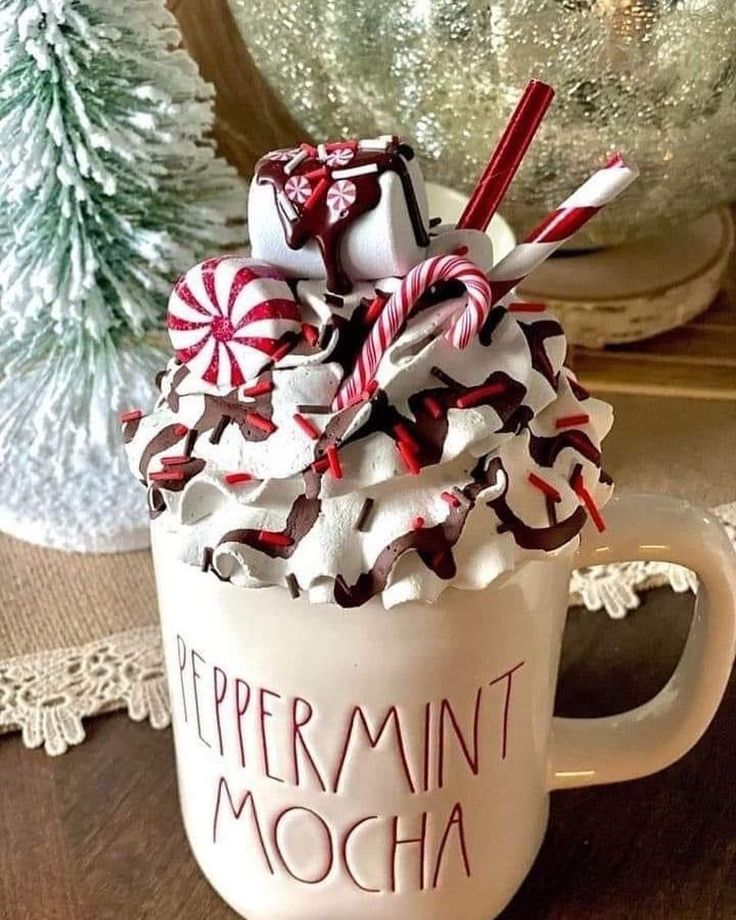 a cup filled with whipped cream and candy canes sitting on top of a table